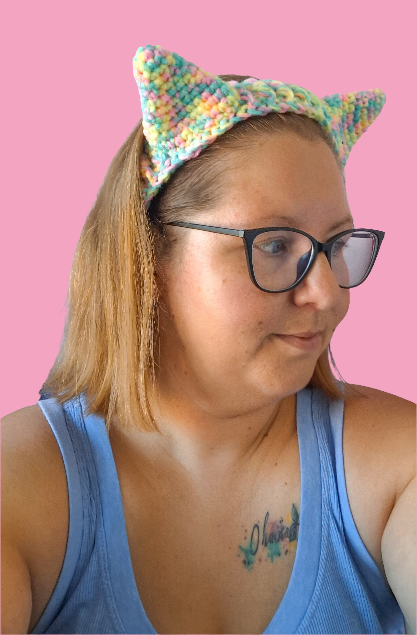 A woman wearing crochet cat ears that have been made using the pattern by crocreate. The cat ears are made with front post and back post double crochet