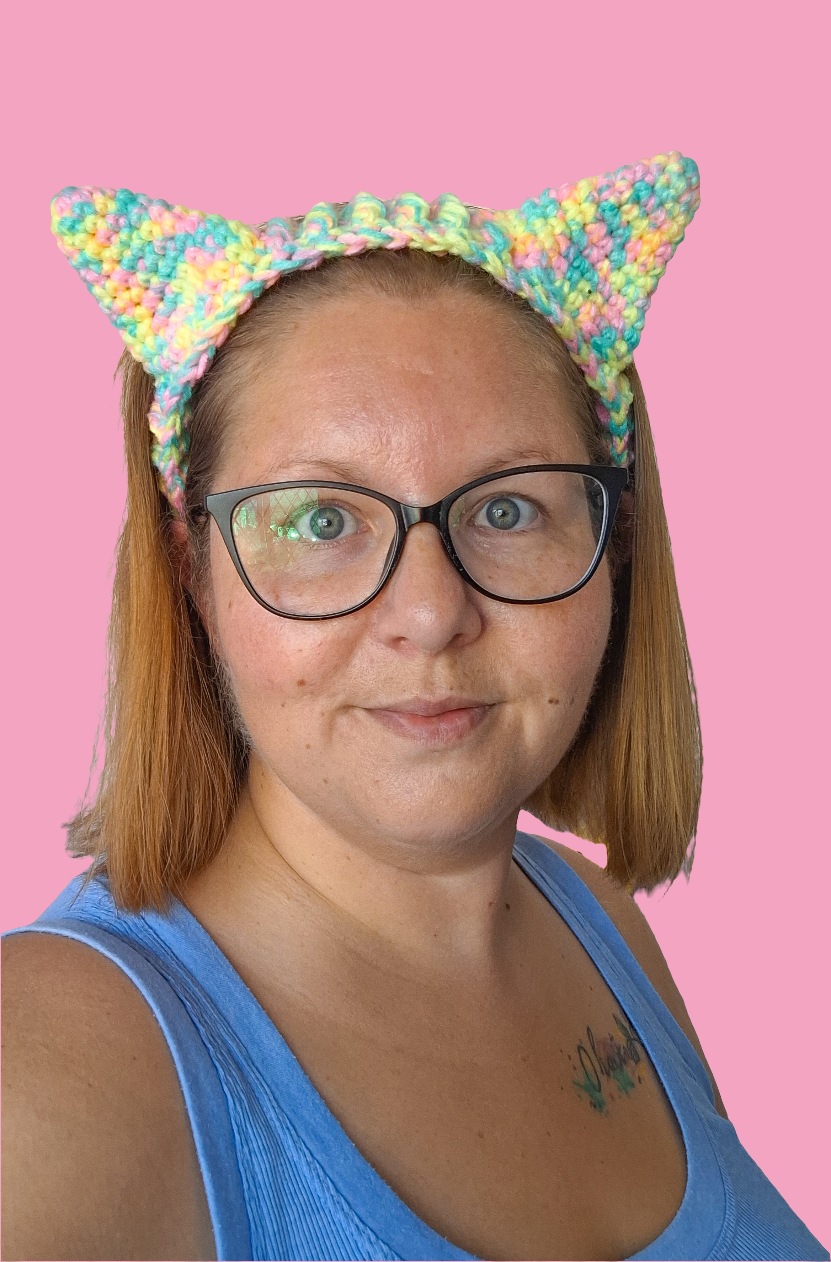 A woman wearing crochet cat ears that have been made using the pattern by crocreate. The cat ears are made with front post and back post double crochet