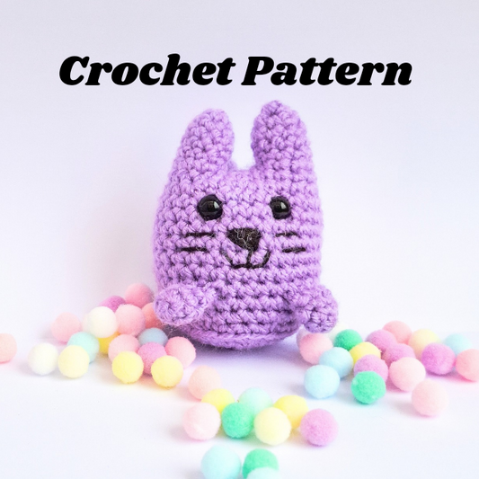 An amigurumi cat crocheted with purple yarn in a kawaii style