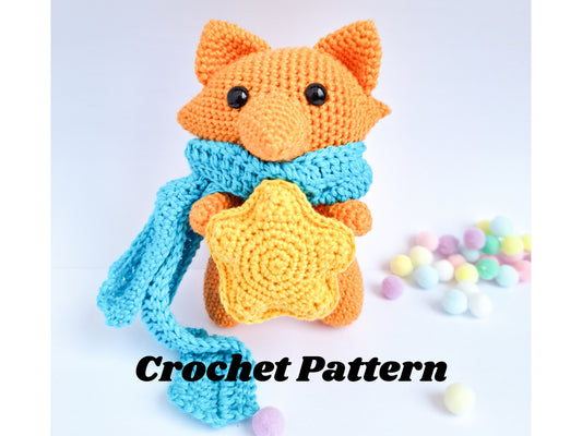 Fox amigurumi crochet made in orange yarn with a blue crochet scarf and a yellow crochet star