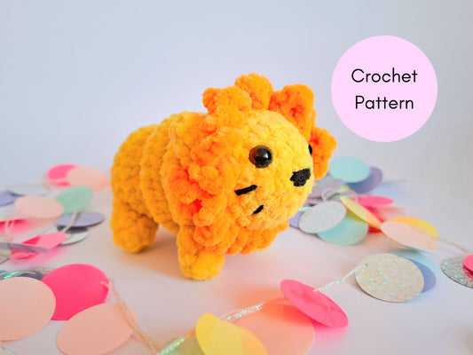 Yellow crochet lion fidget toy with an orange mane and whiskers standing on a plain background