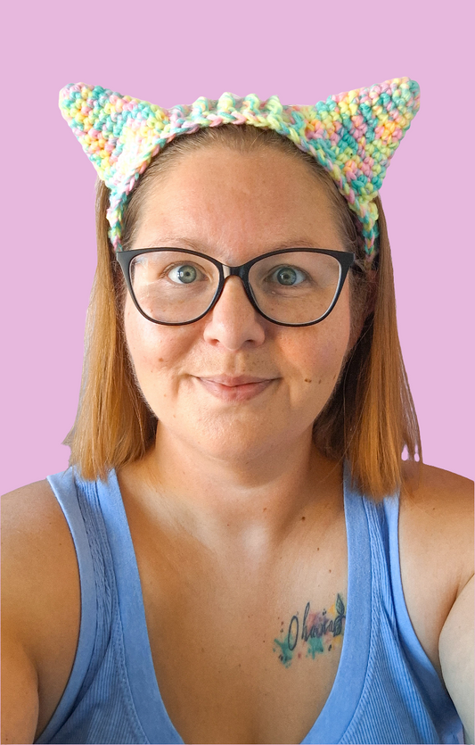 A woman wearing crochet cat ears that have been made using the pattern by crocreate. The cat ears are made with front post and back post double crochet 